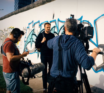 Local Producer on loacation at the remains of the Berlin Wall. When producing documentary, time is money and time is story telling time